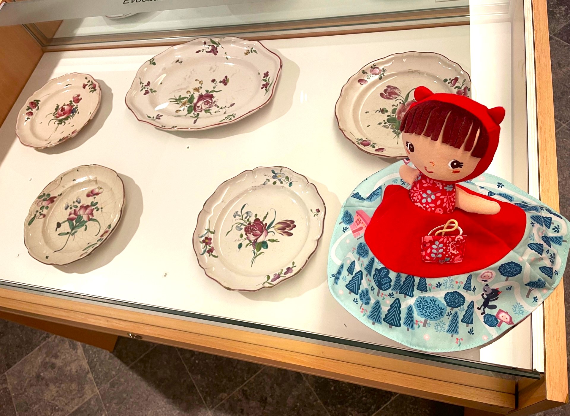 photographie de la marionnette Judy sur une vitrine d'exposition de la salle de faïences.