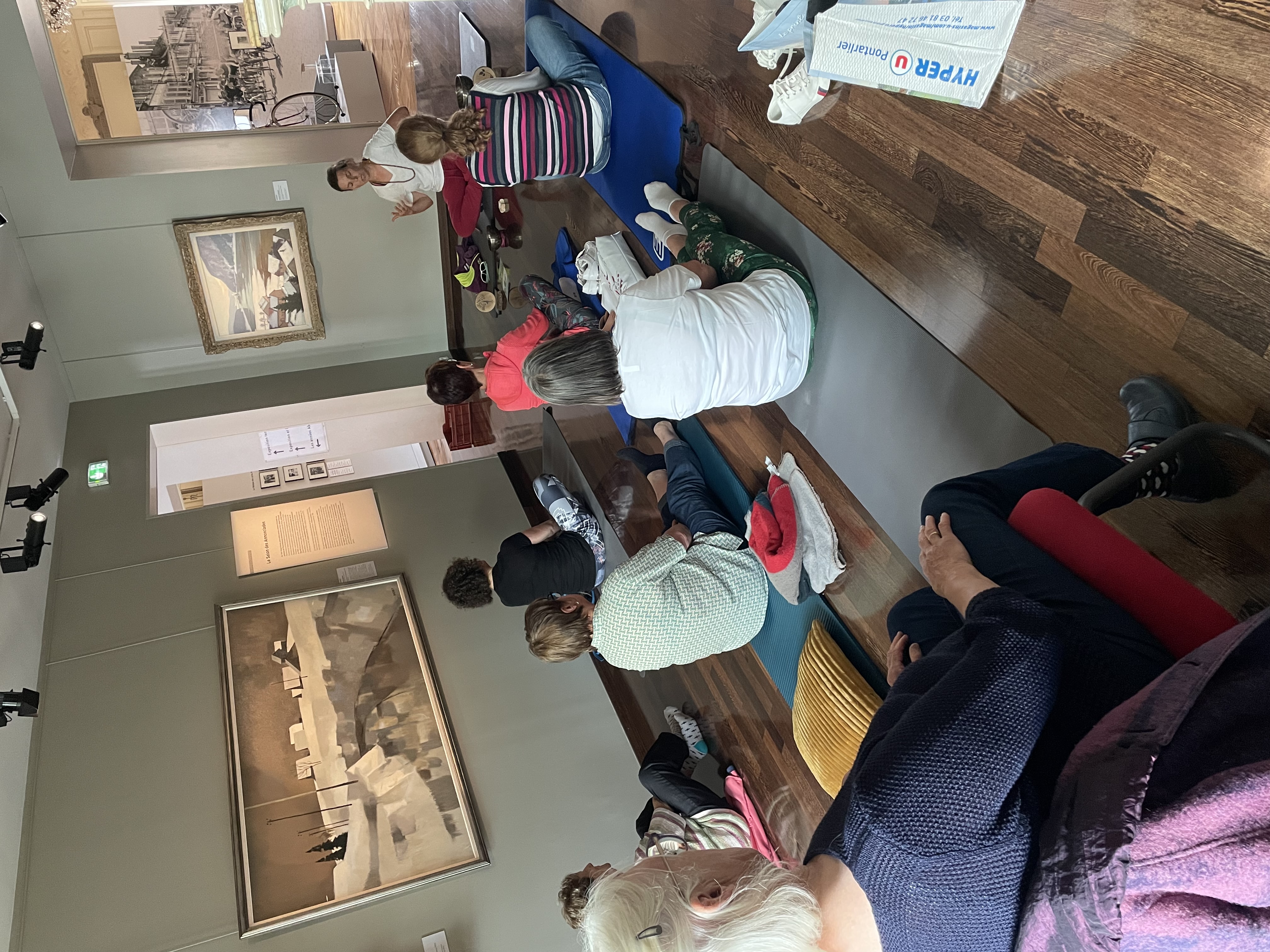photographie d'une séance de méditation au milieu des peintures de paysage de l'Ecole comtoise.